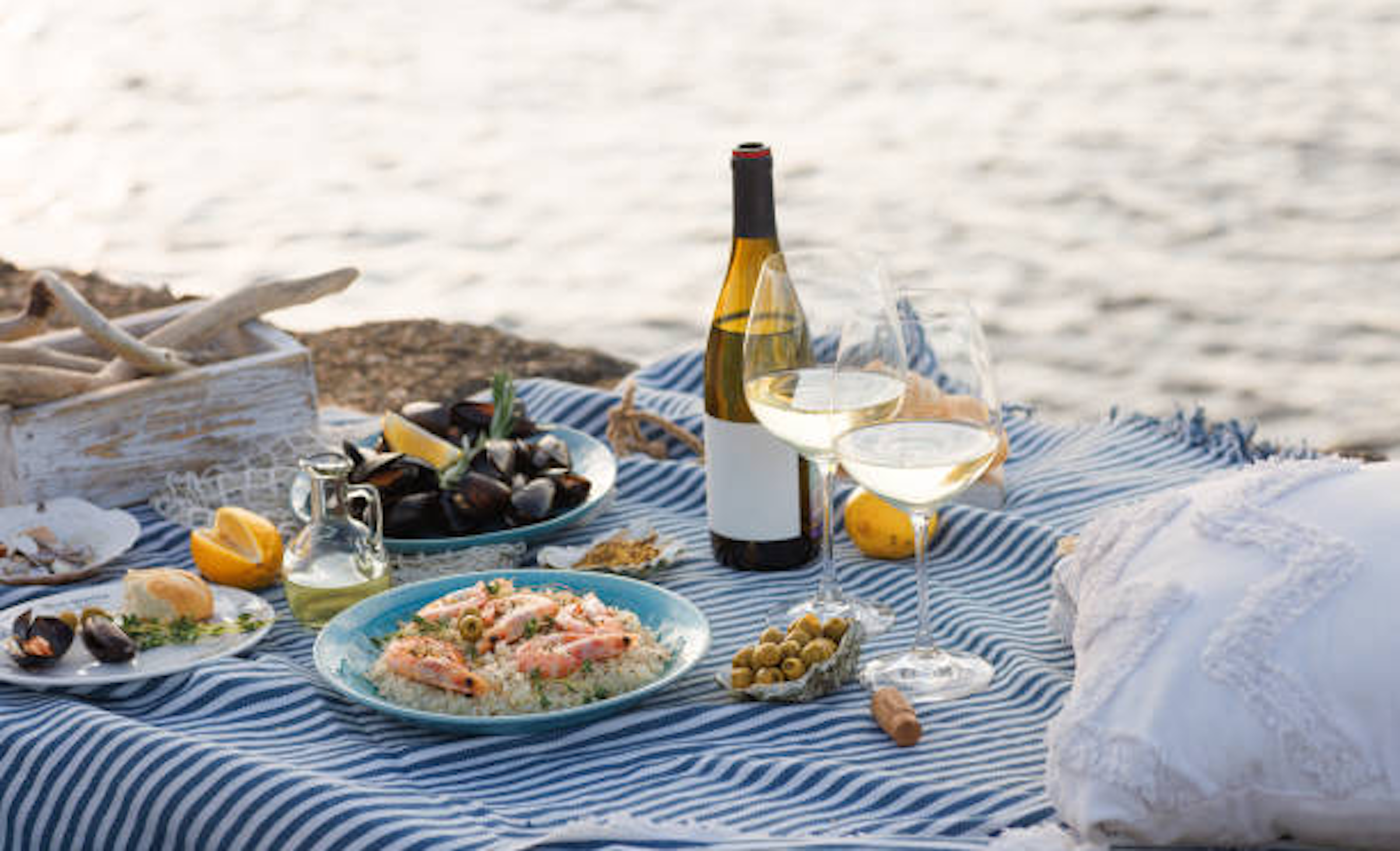 Pique-nique en bord de mer avec nappe, vin et nourriture