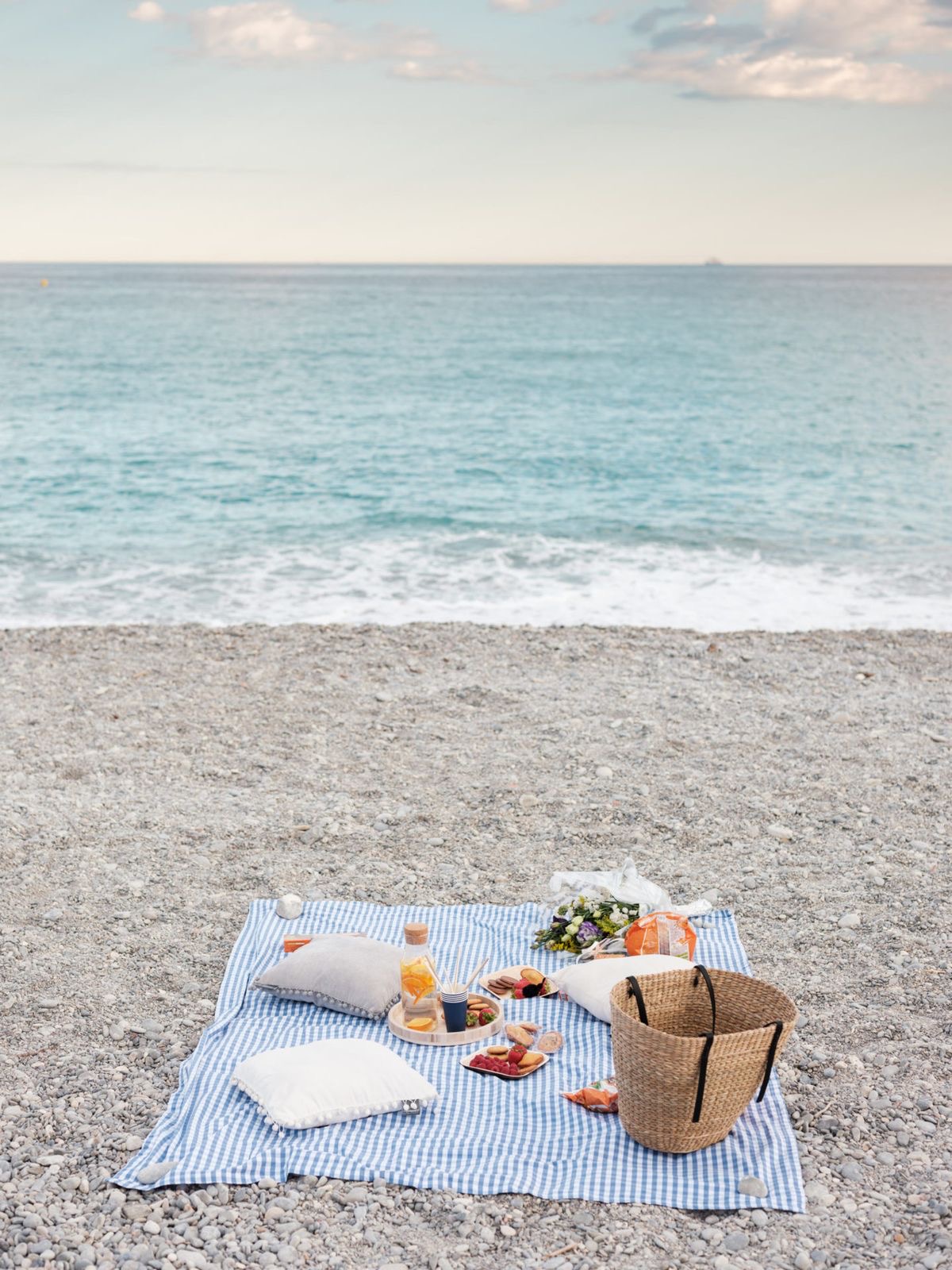 Pique-nique avec panier et nappes sur les galets de la plage de Nice