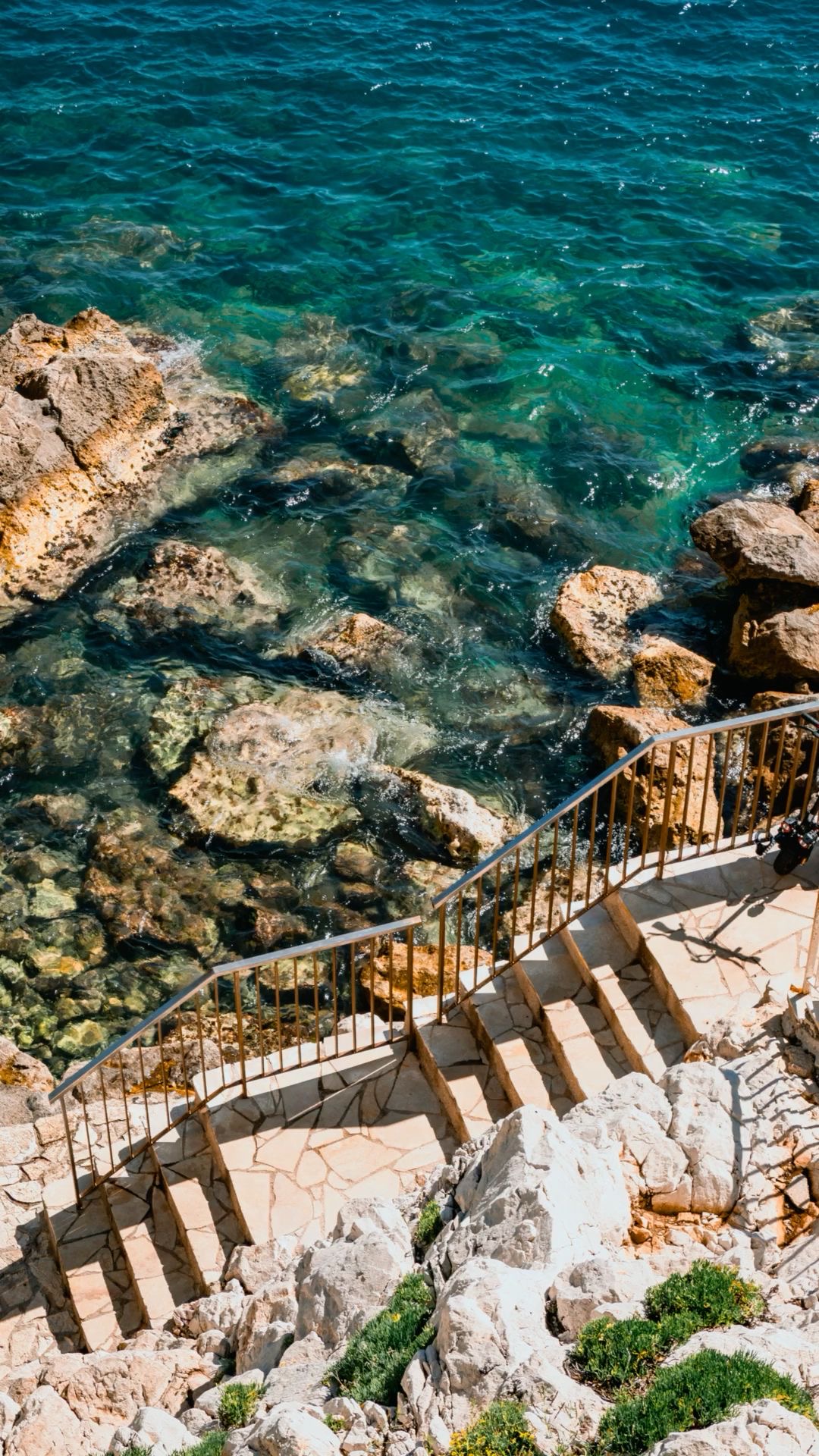 Roches et mer turquoise avec escaliers