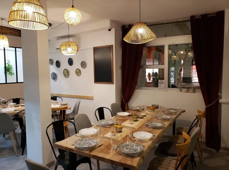 Salle de restaurant chaleureuse avec table dressée pour 9 personnes