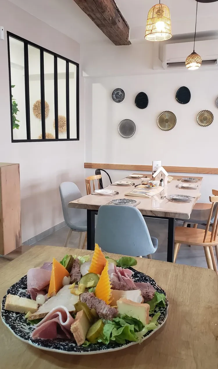 Assiette de fromages et charcuteries dans une salle de restaurant lumineuse