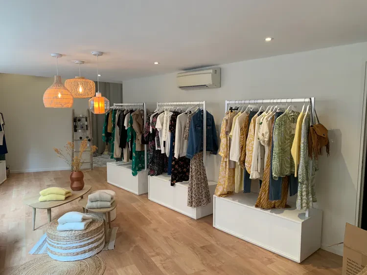 Intérieur de boutique avec vêtements sur portants