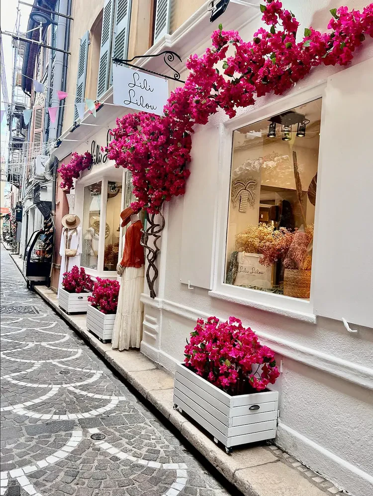 Devanture d'une boutique blanche avec des fleurs roses