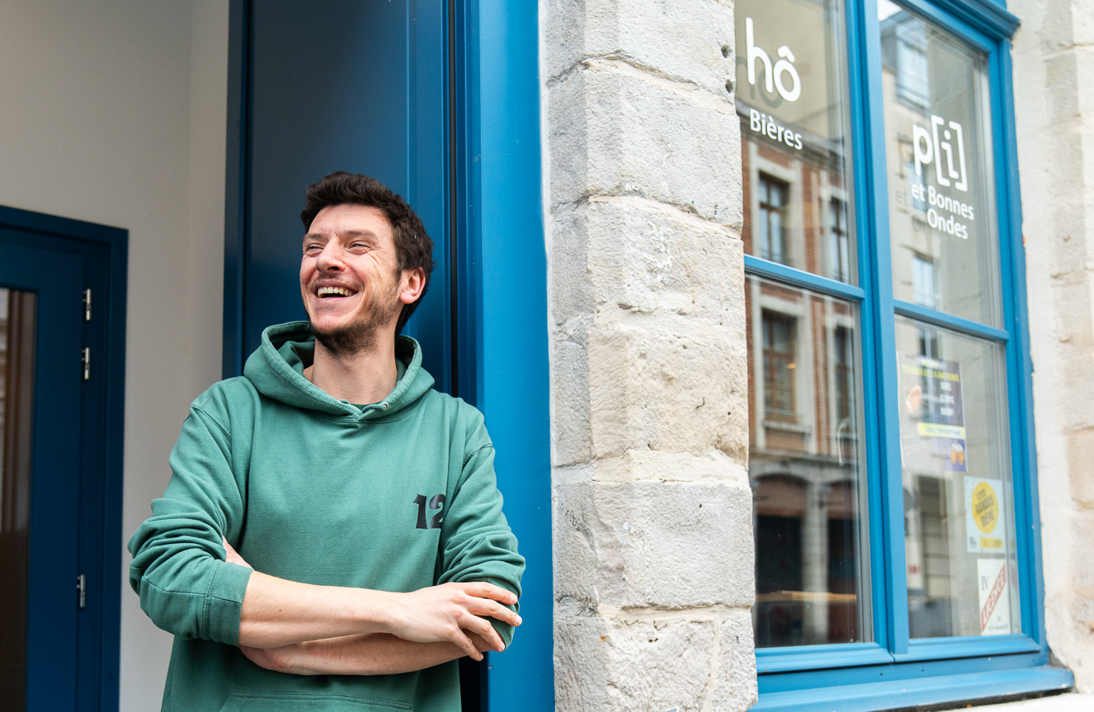 Homme qui pose devant une boutique