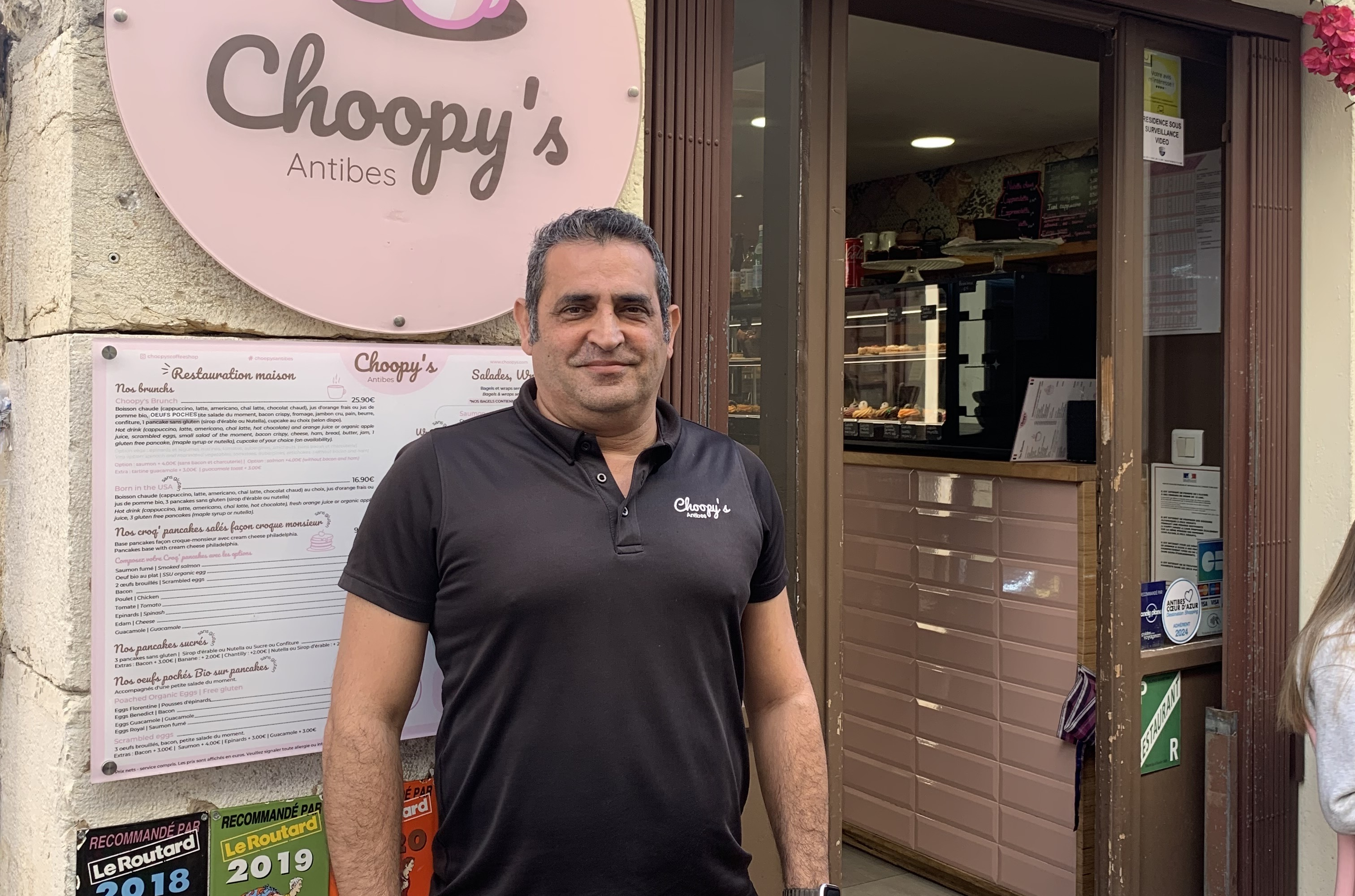 portrait d'un homme devant son magasin