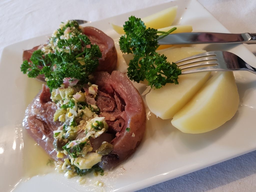 Tête de veau servie dans une assiette avec des pommes de terre
