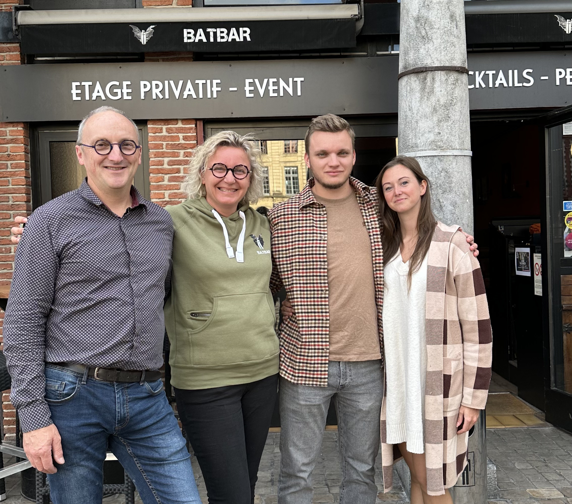4 personnes qui prennent la pose devant un restaurant