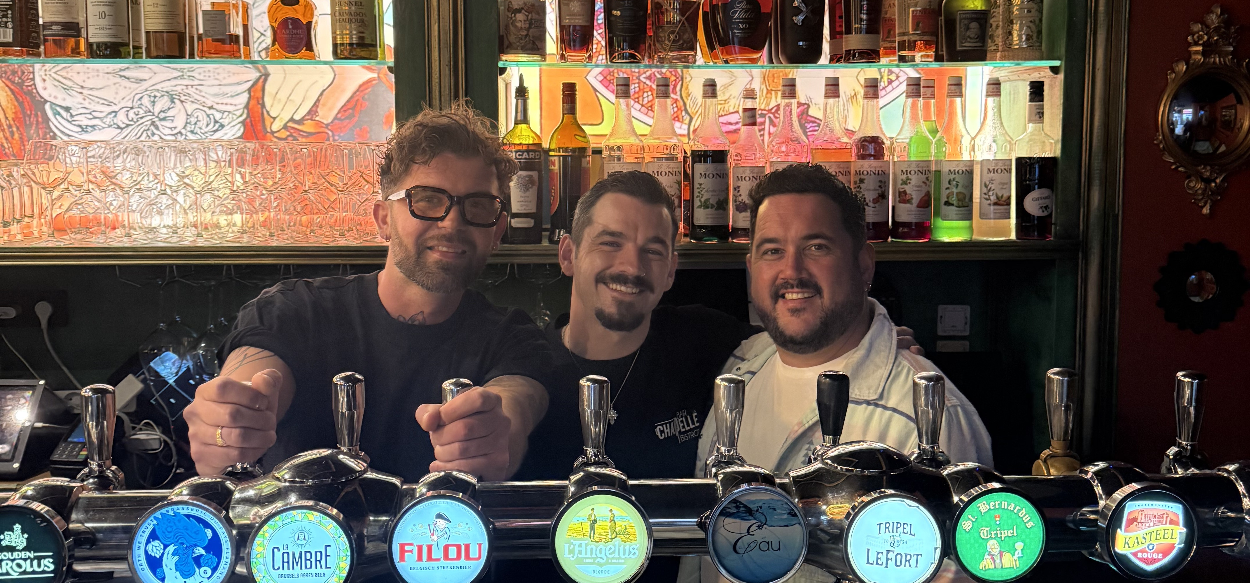 3 hommes derrière un comptoir de bar