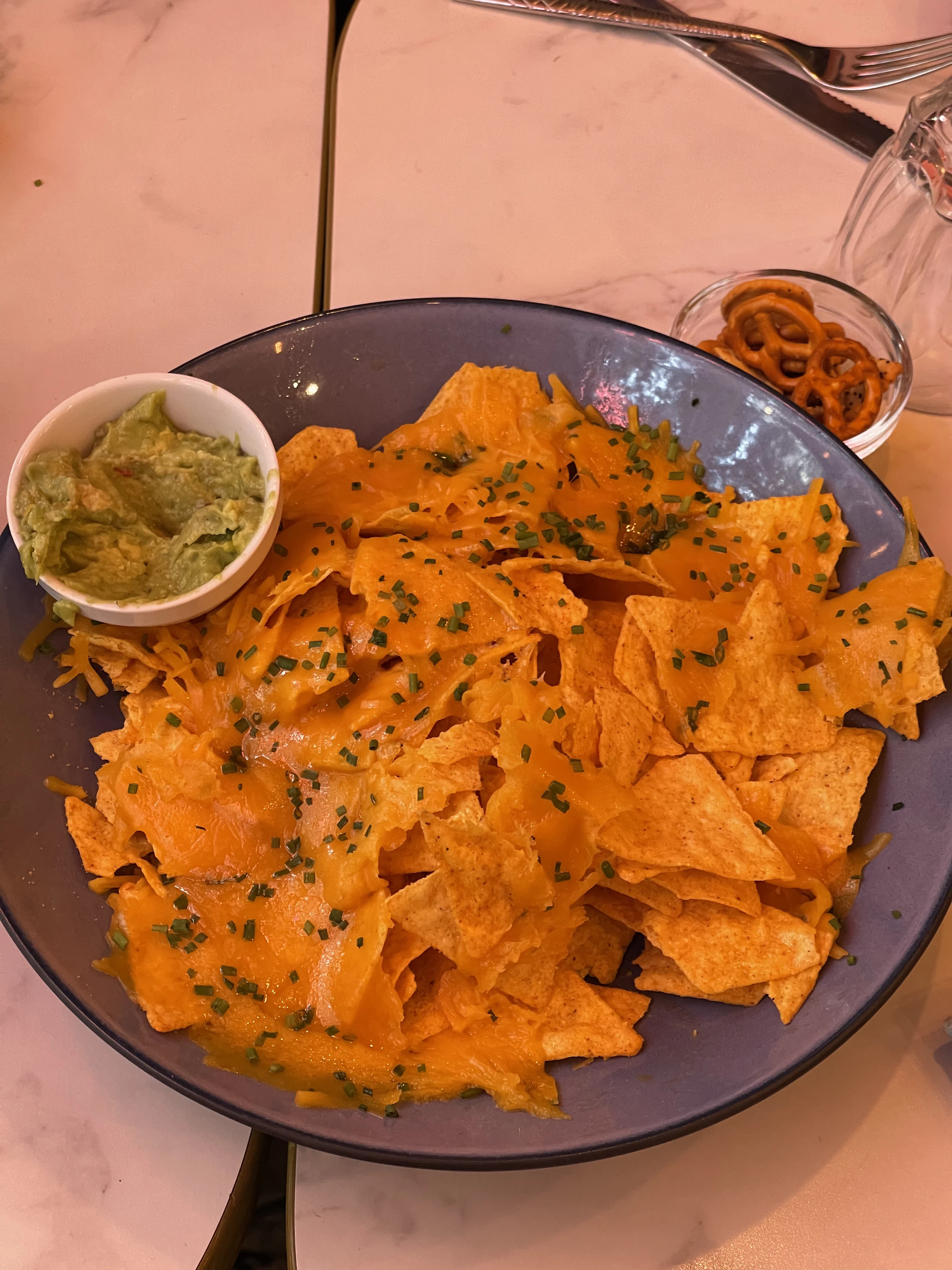 Des nachos avec des sauces dans une assiette