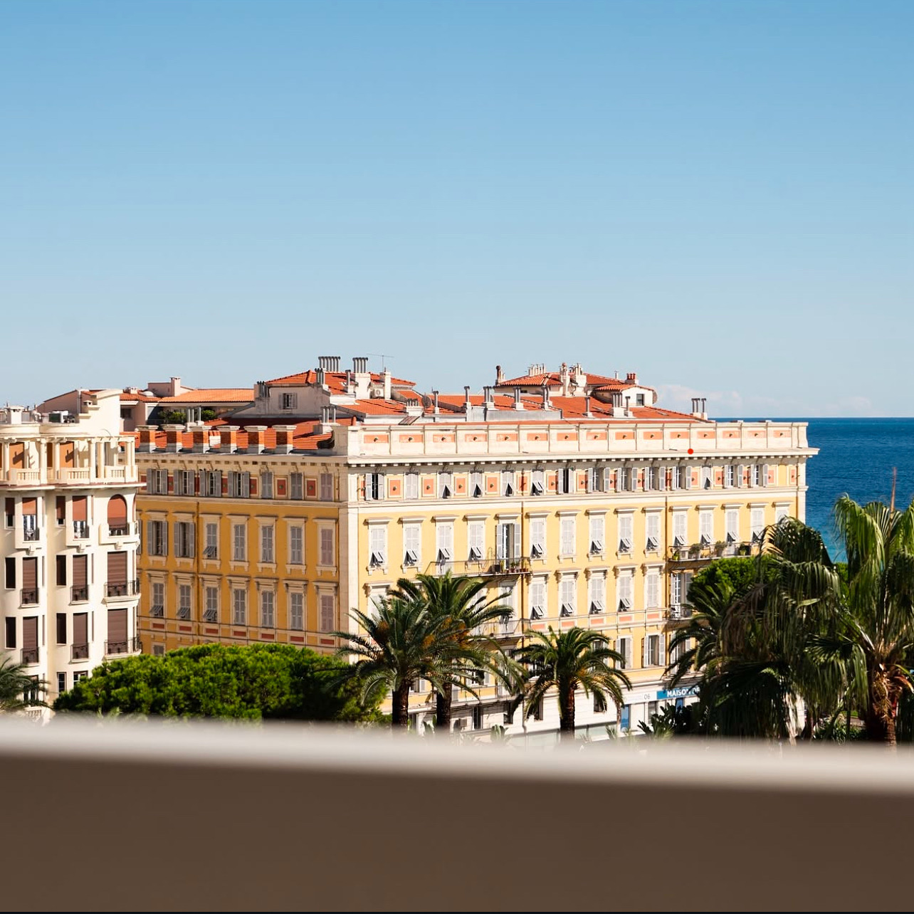 Vue mer avec bâtiments colorés et palmiers