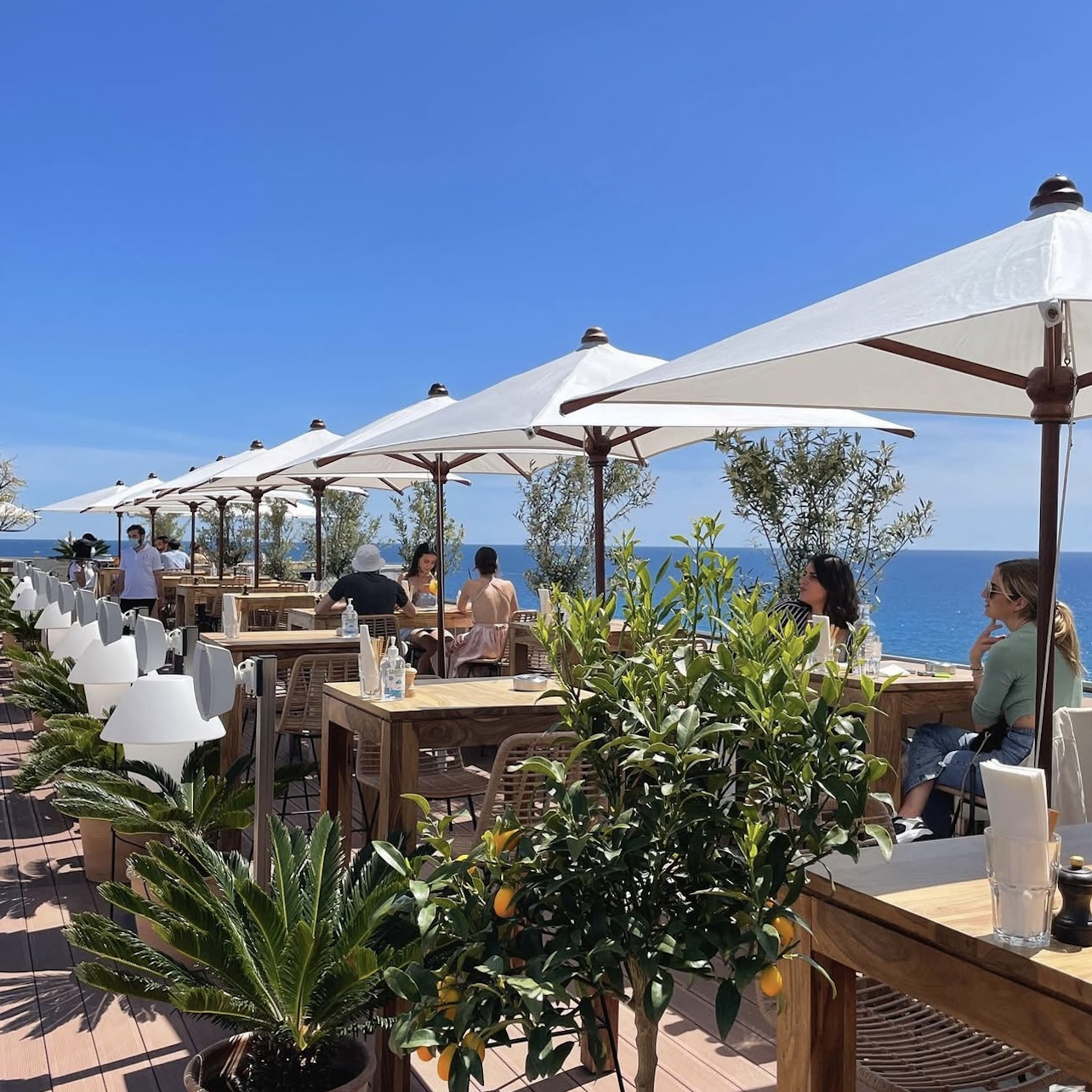 Tables alignées avec parasols et vue mer