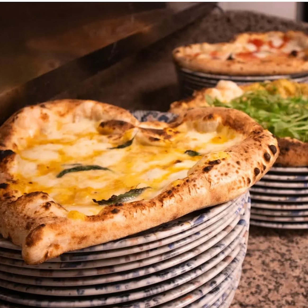 Plusieurs pizzas posées dans des assiettes