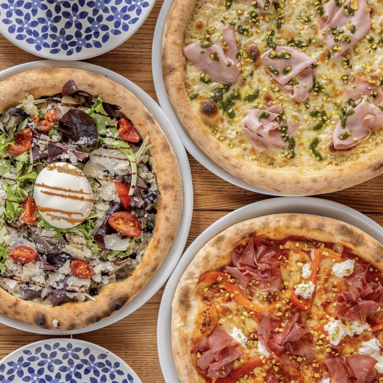 Trois pizzas posées dans des assiettes
