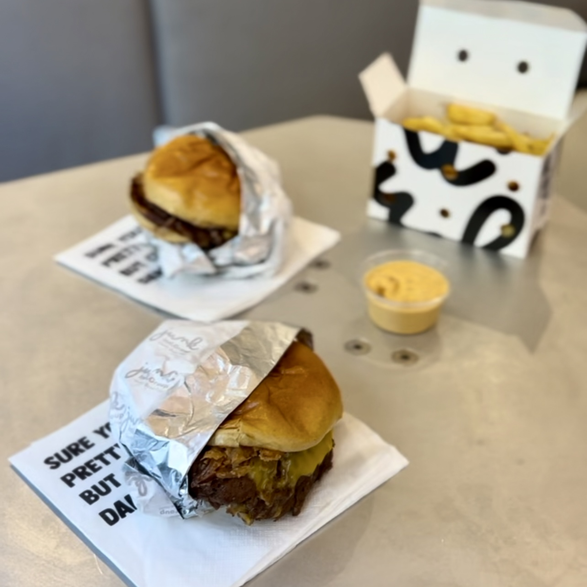Deux burgers avec une sauce et des frites