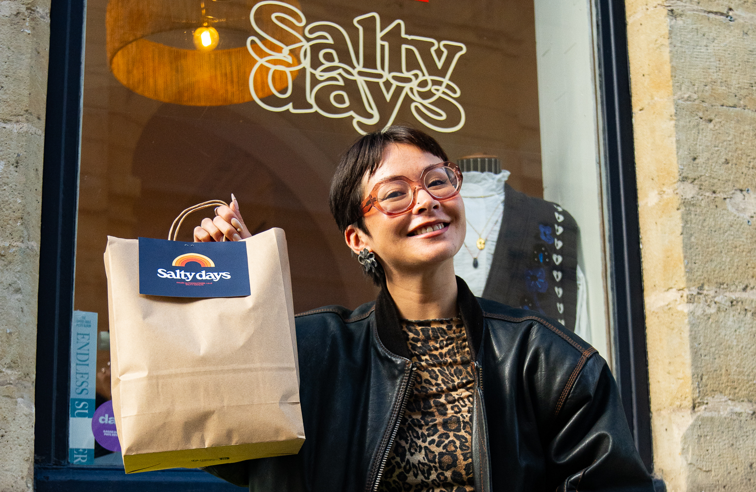 Femme souriante devant un magasin
