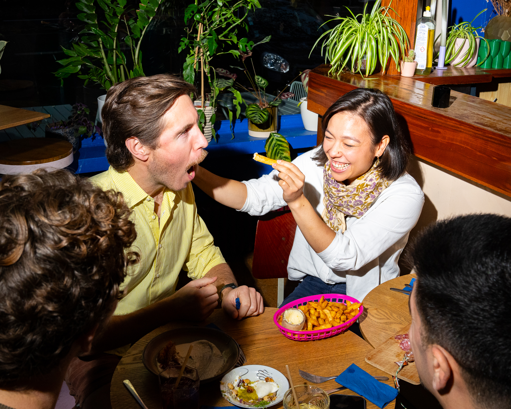 2 personnes assises dans un restaurant qui mangent une frite