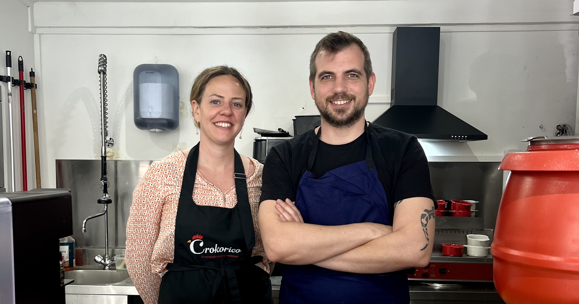 Un homme et une femme en tabliers derrière un comptoir