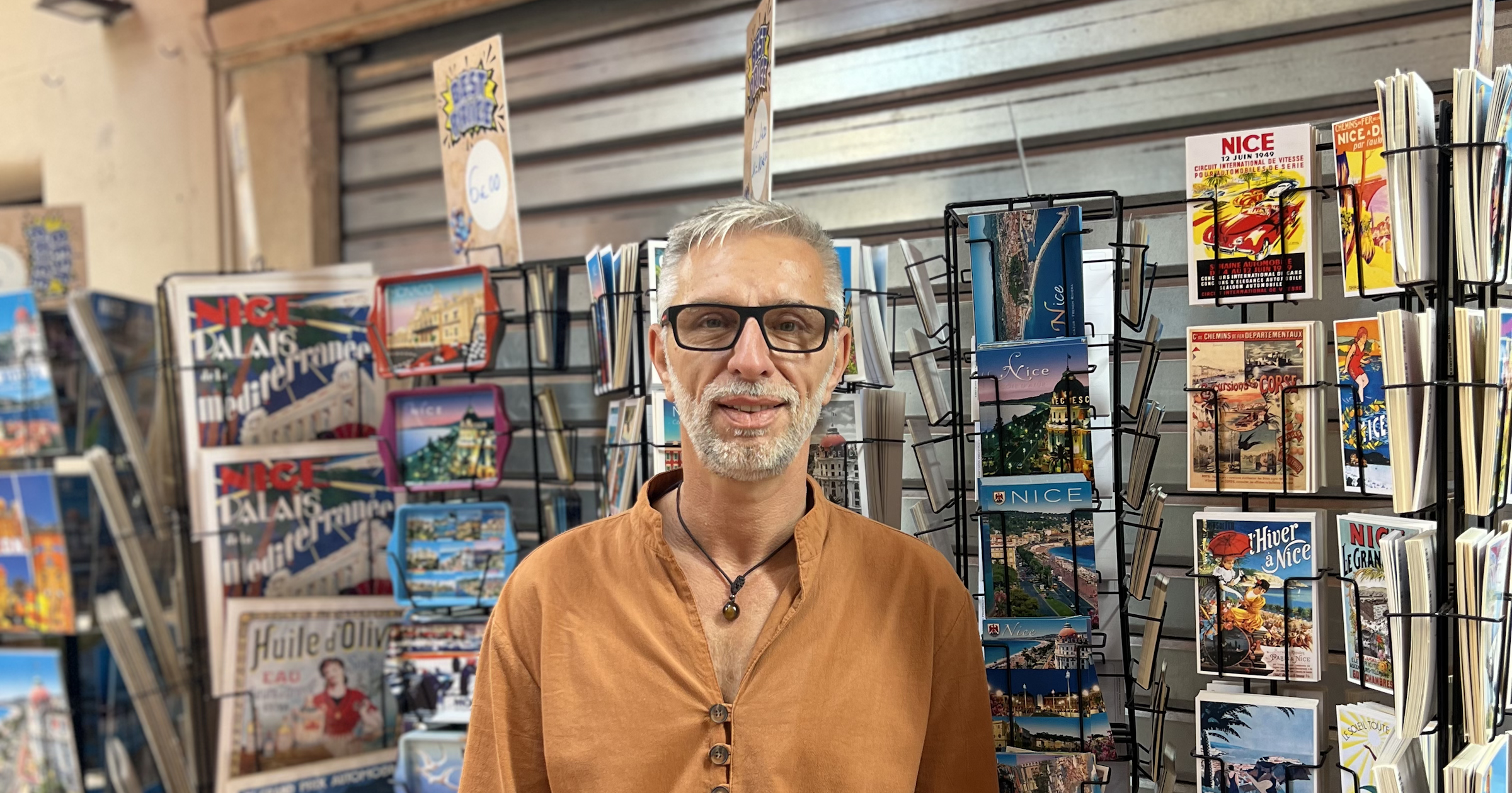 homme debout avec cartes postales en fond