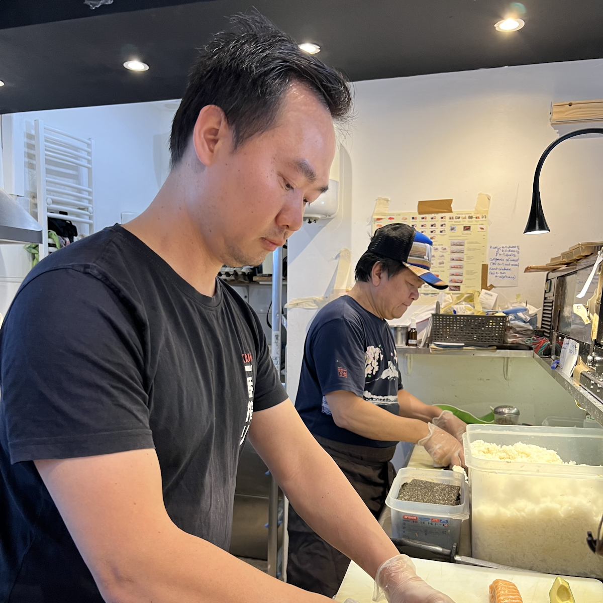 Deux hommes en train de réaliser des sushis