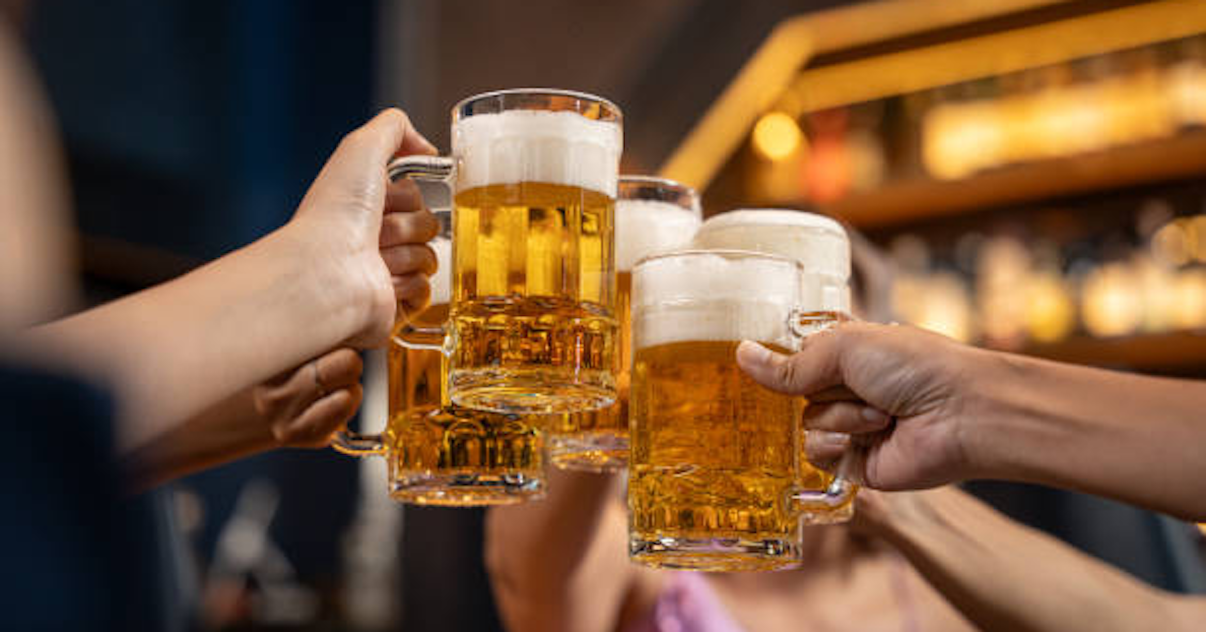 Personnes trinquant tenant chacun une pinte de bière
