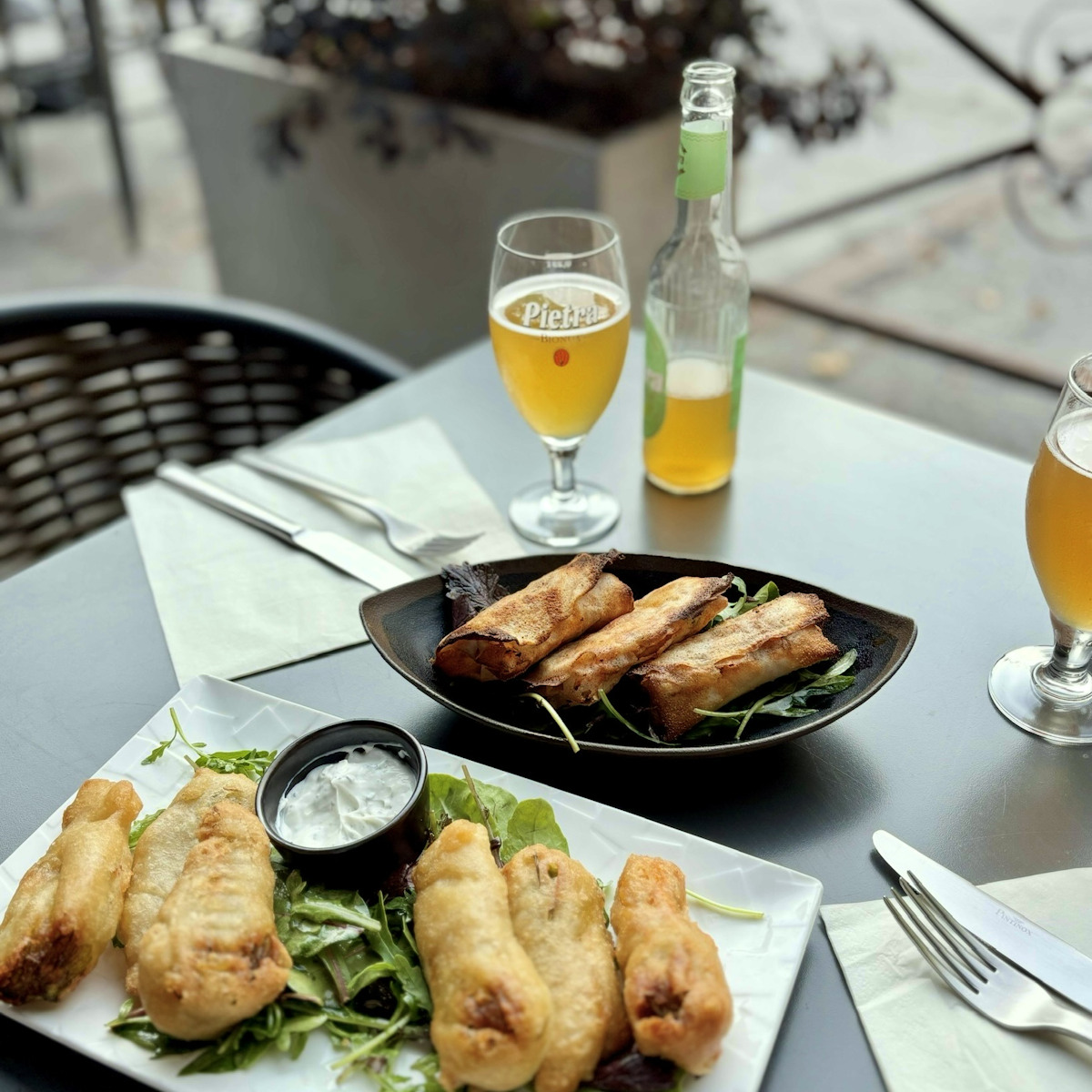 Tables remplie d'assiettes avec briques et beignets ainsi qu'une bière