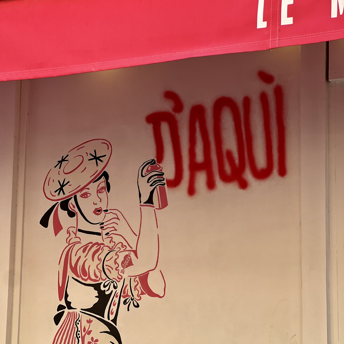 Devanture avec graffiti d'une niçoise en tenue traditionnelle