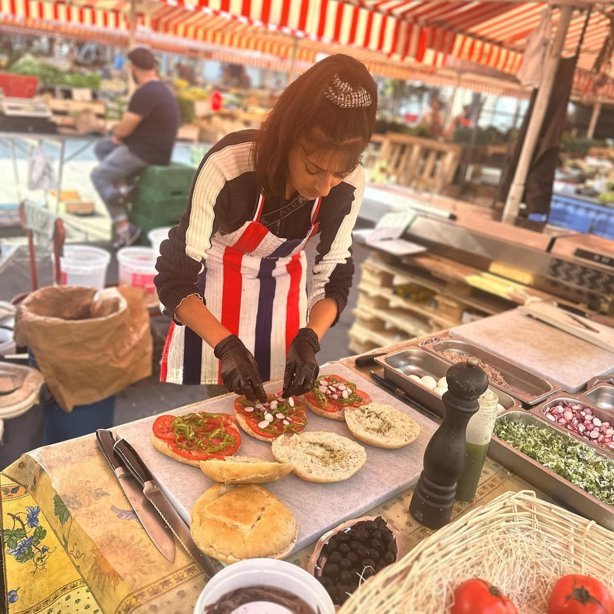 Femme préparant des pan bagnats sur le marché