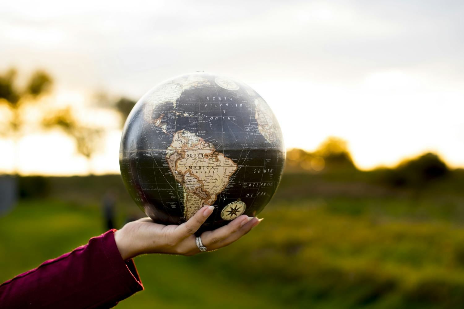 mão segurando uma esfera que representa o planeta Terra