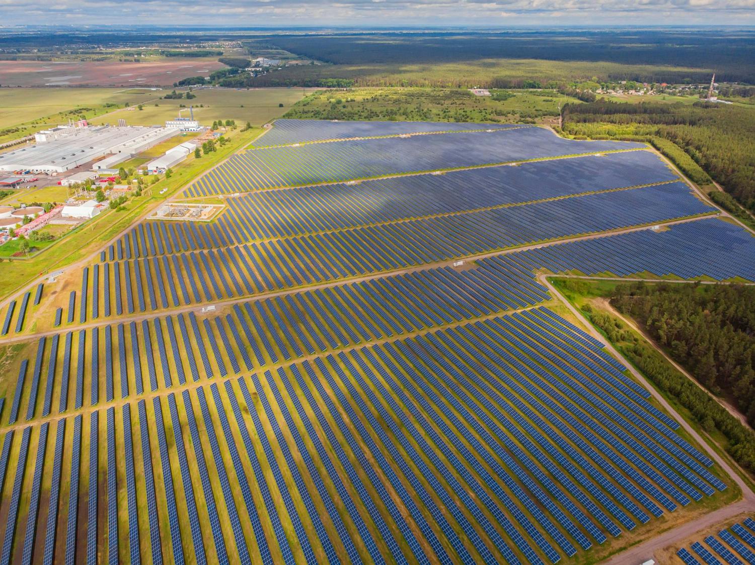grande espaço rural com muitas placas solares, conhecido como fazendas solares