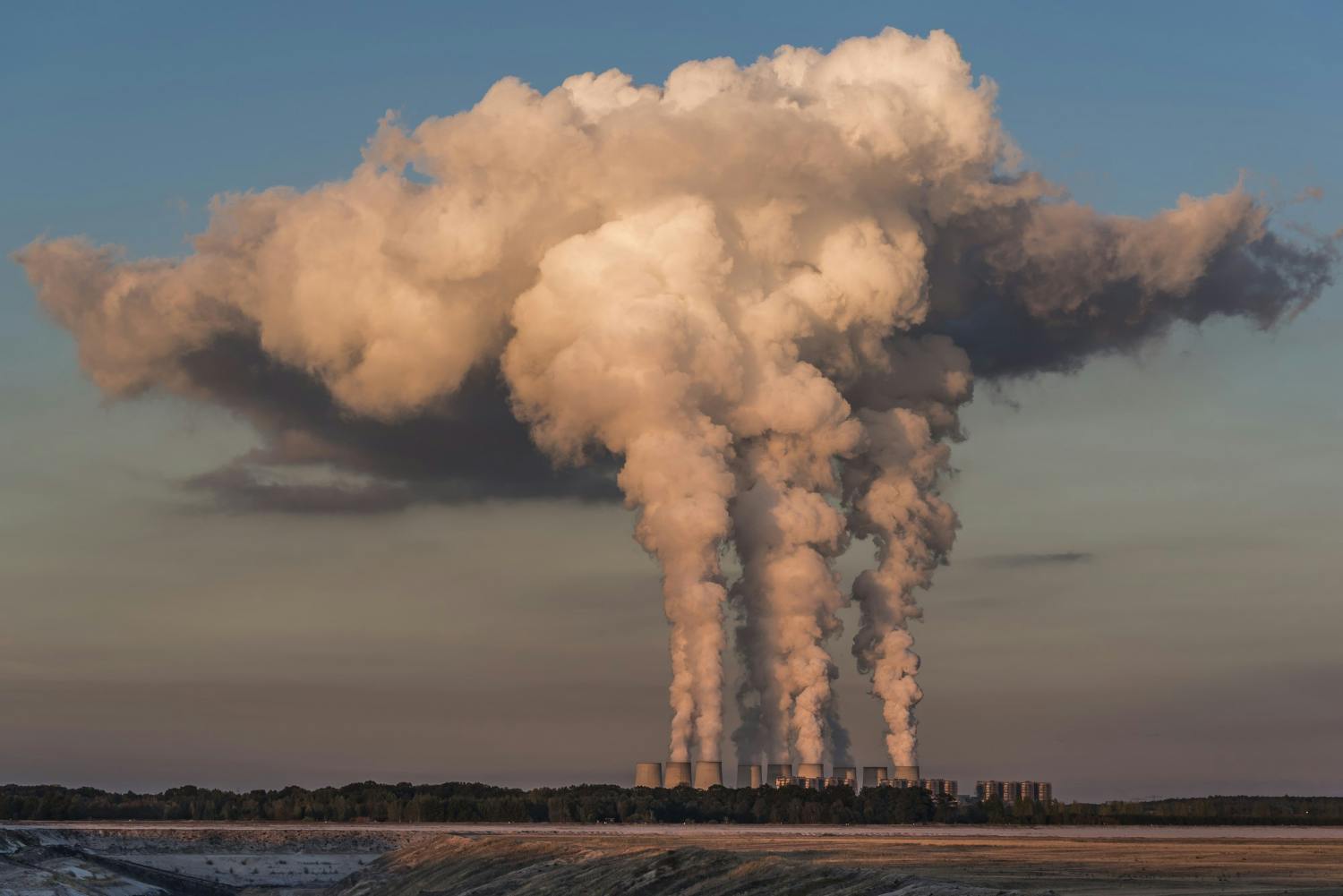 imagem de usinas jogando muita fumaça na atmosfera contribuindo para o aquecimento global