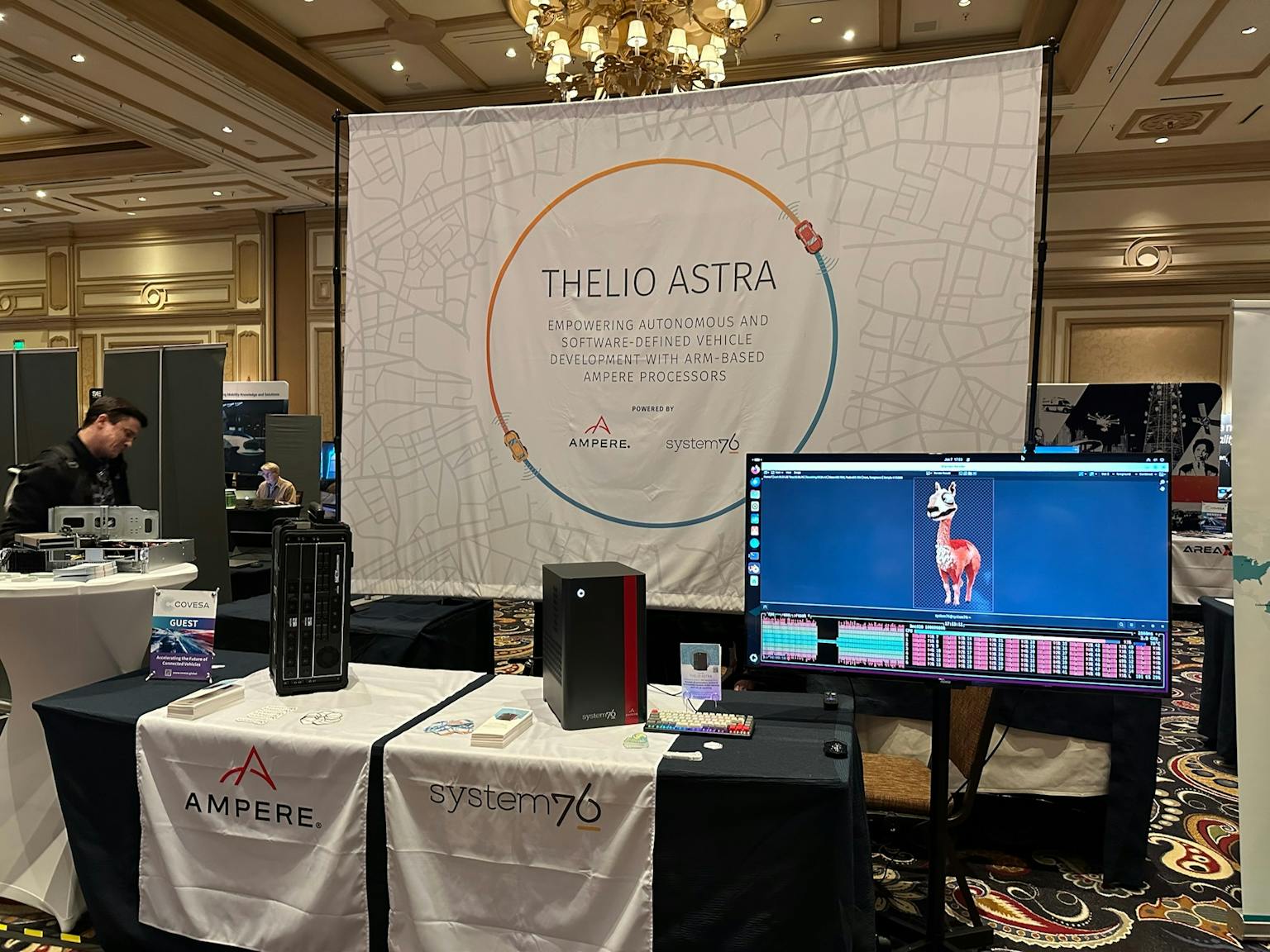 Photo of Thelio Astra showcased at Ampere’s booth. It is rendering a llama in need of therapy alongside a program that monitors CPU activity.
