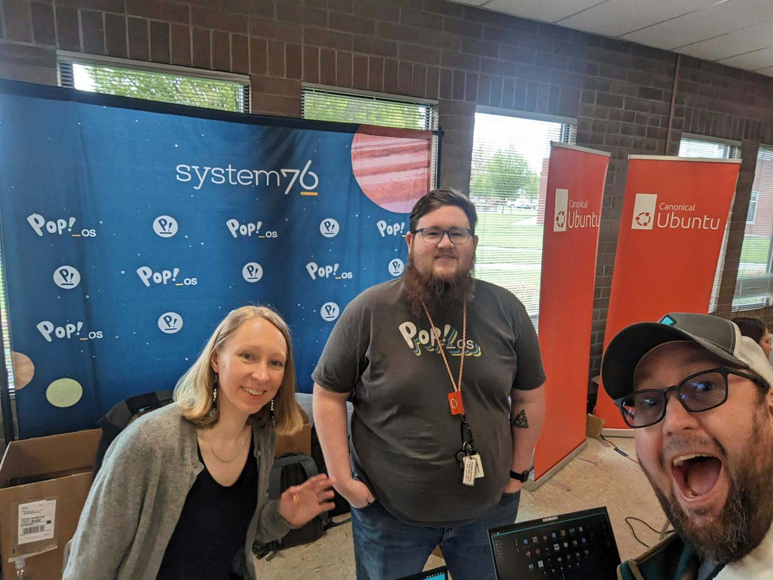 Maria and Aaron and Mike standing in front of the System76 Booth at LinuxFest Northwest