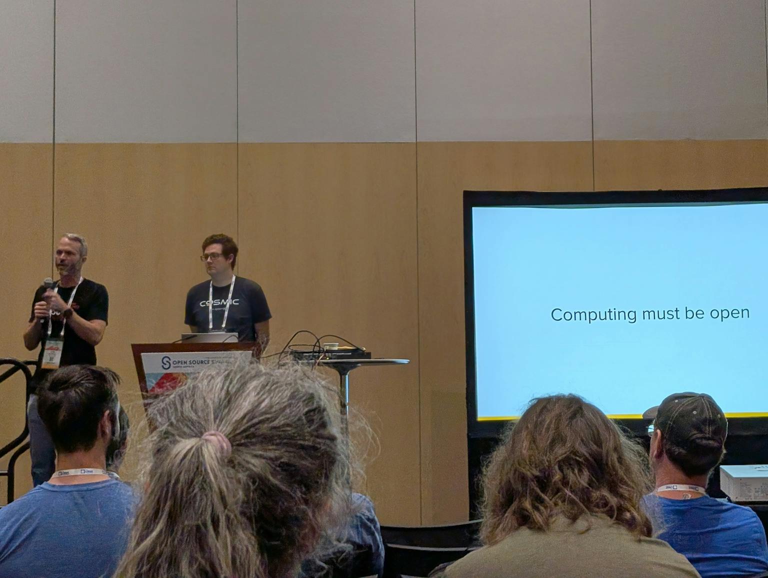 Carl and Jeremy standing next to screen that has the words Computing must be open
