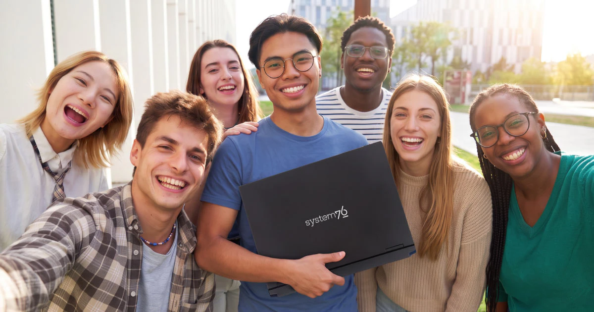 college students smiling and holding up an Adder Pro laptop