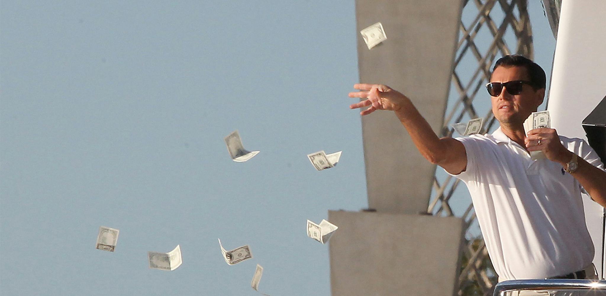 Hombre arrojando dinero por la ventana.