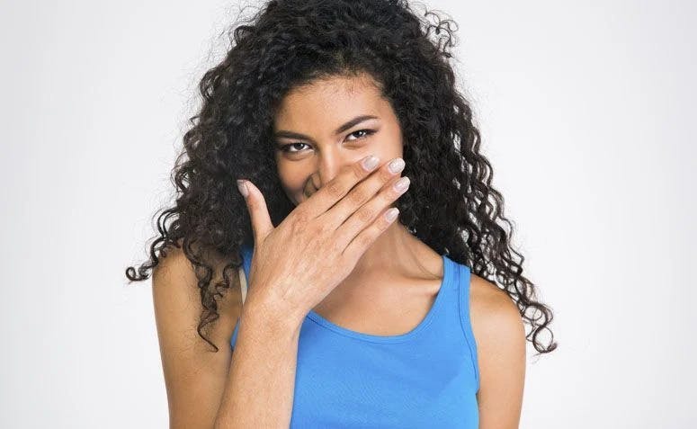 Woman with hand over mouth