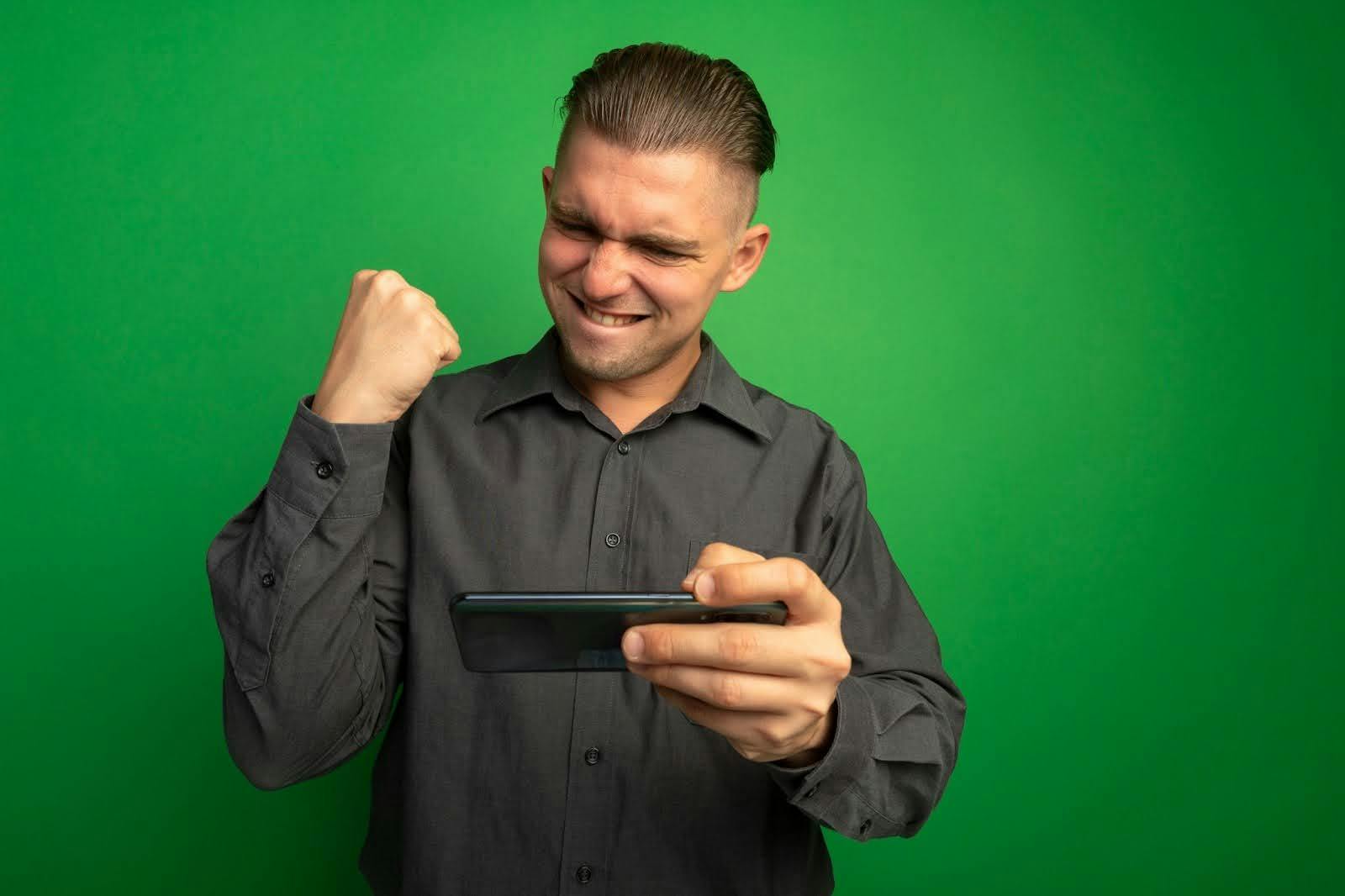 Homem vibrando segurando celular