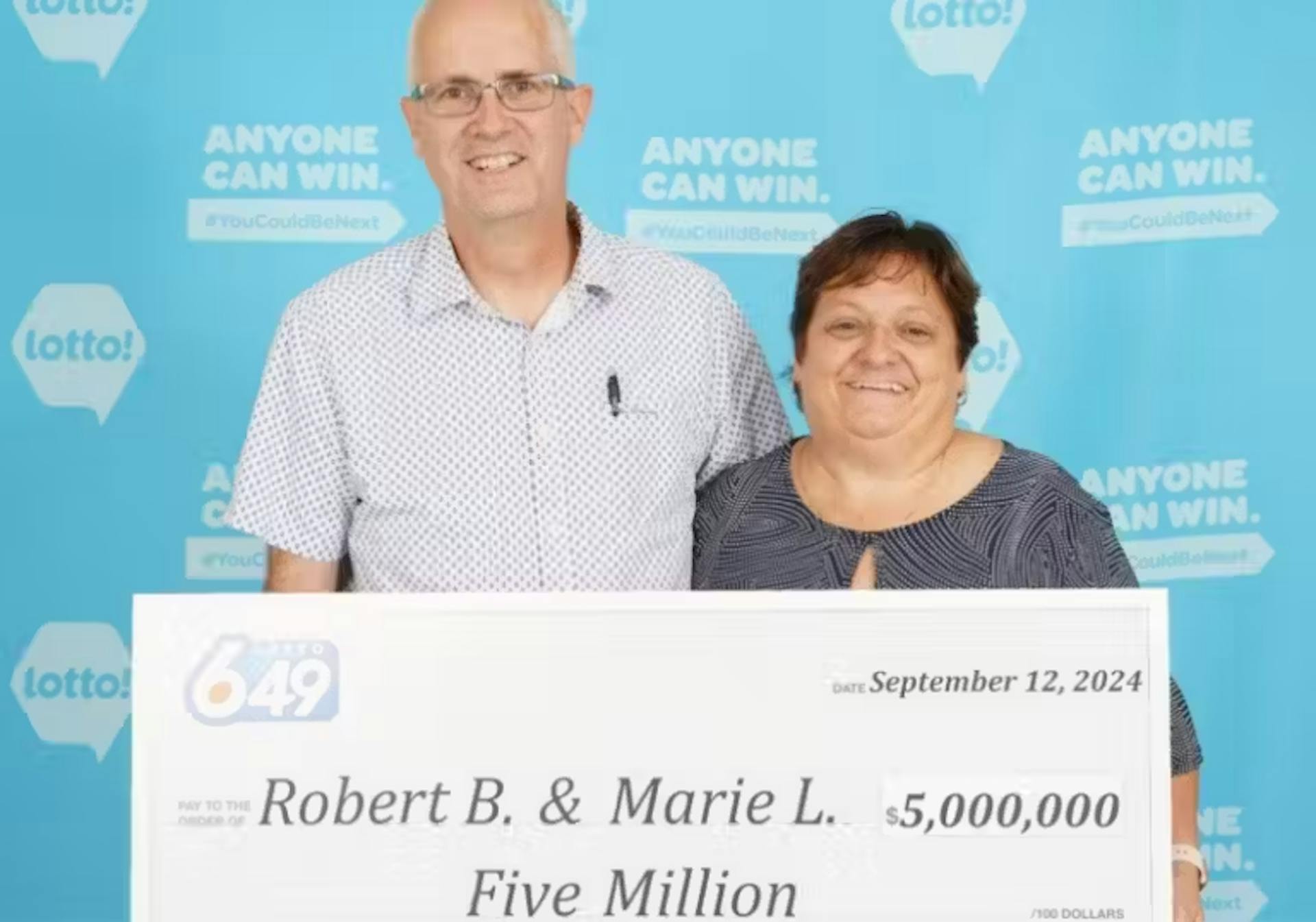 Pareja sosteniendo el premio de la lotería