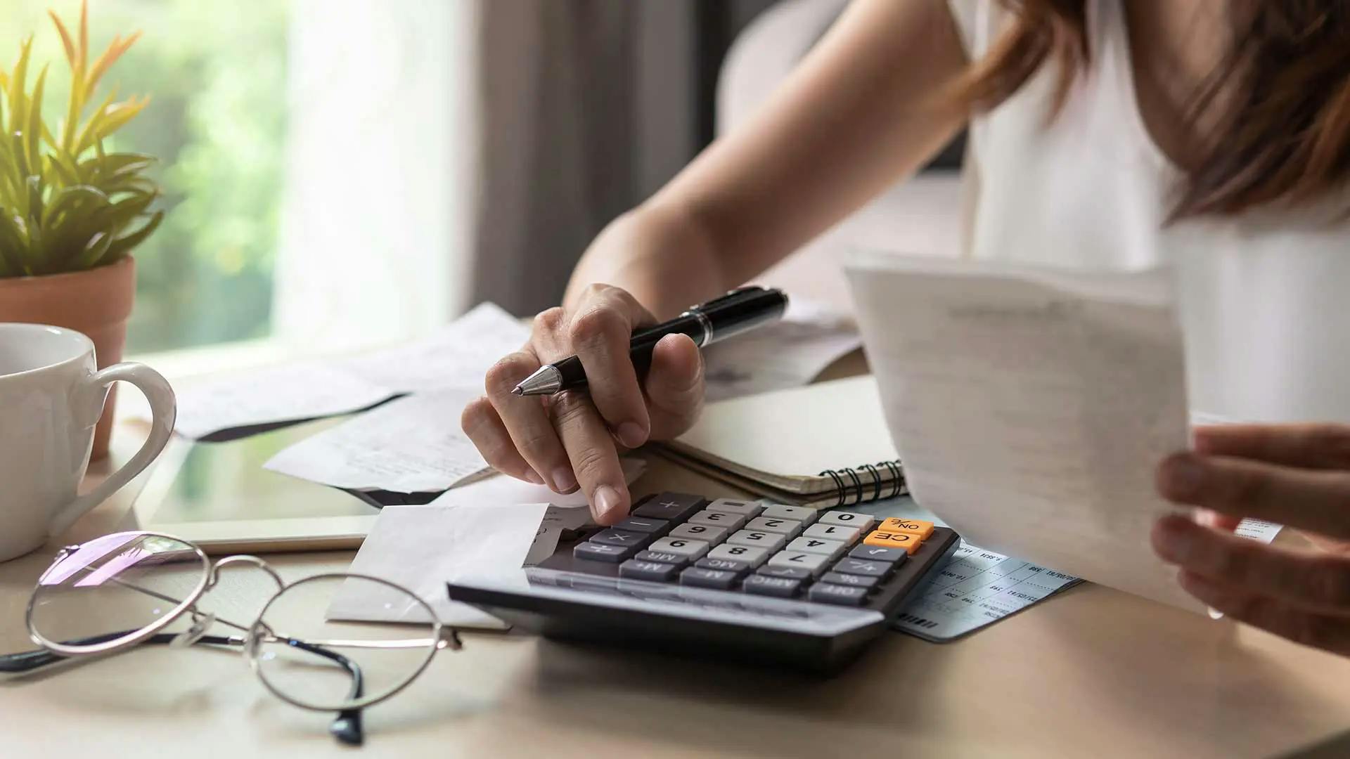 Woman with a calculator holding paper