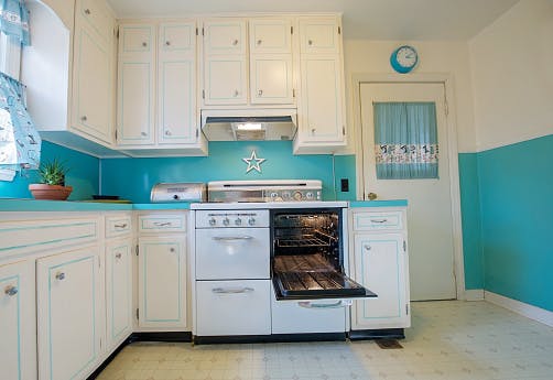 Cozinha retrô com cores claras e móveis rústicos de madeira.