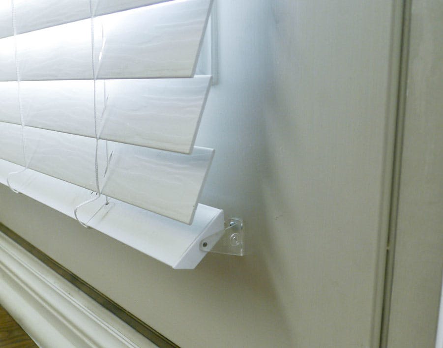 white blinds on door with hold down bracket