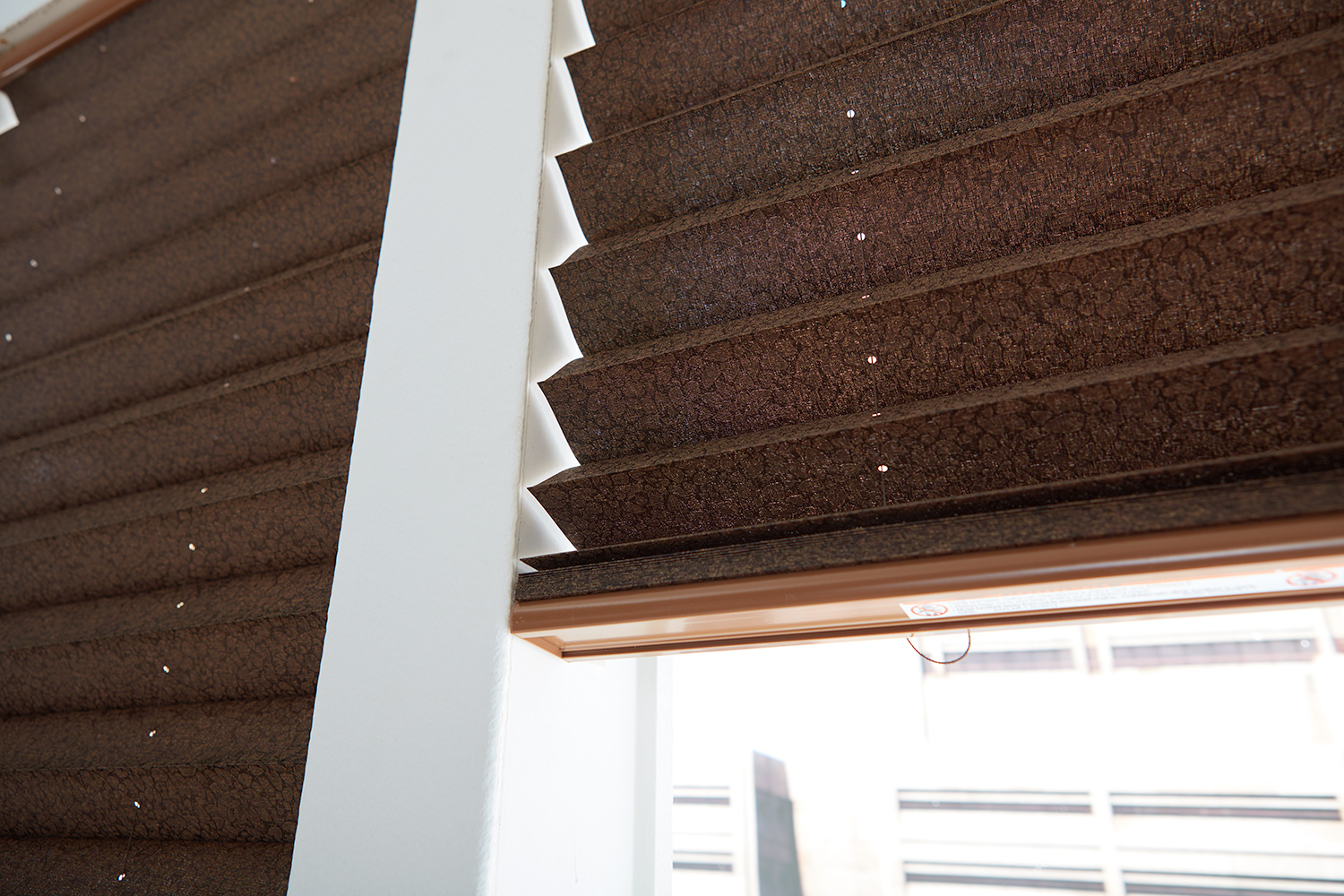 closeup of brown fabric pleated shades