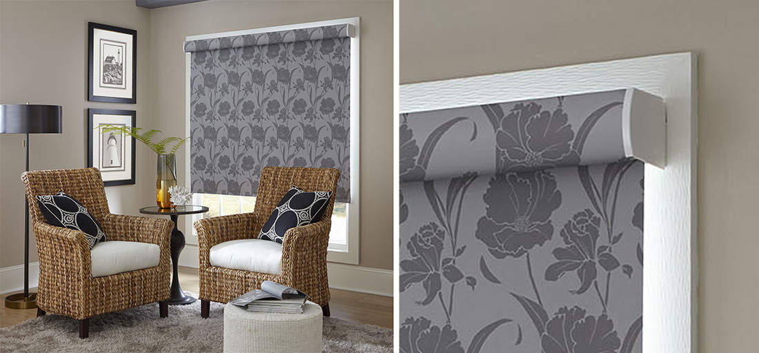 living room corner with two wicker chairs and a grey, floral solar roller shade lowered over the window.