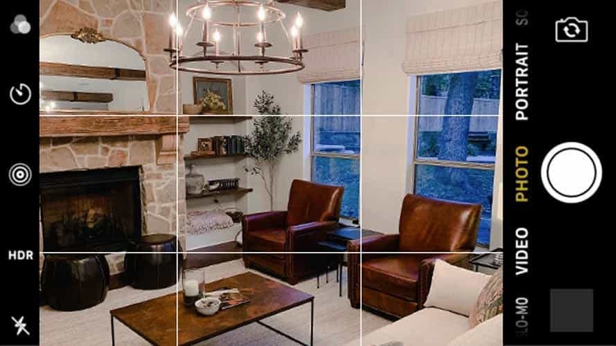 contemporary living room with chandelier and leather chairs. photo has grid overlay like it's being viewed through a camera phone.