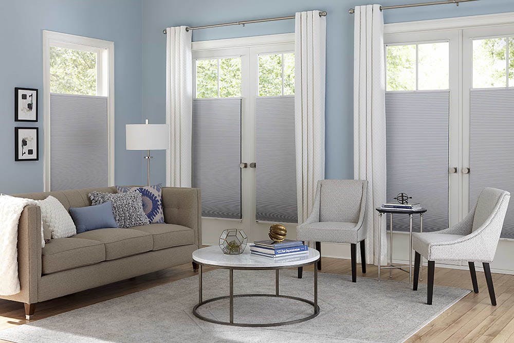 Contemporary blue and beige living room with white, top-down bottom-up cellular shades over the windows and french doors.