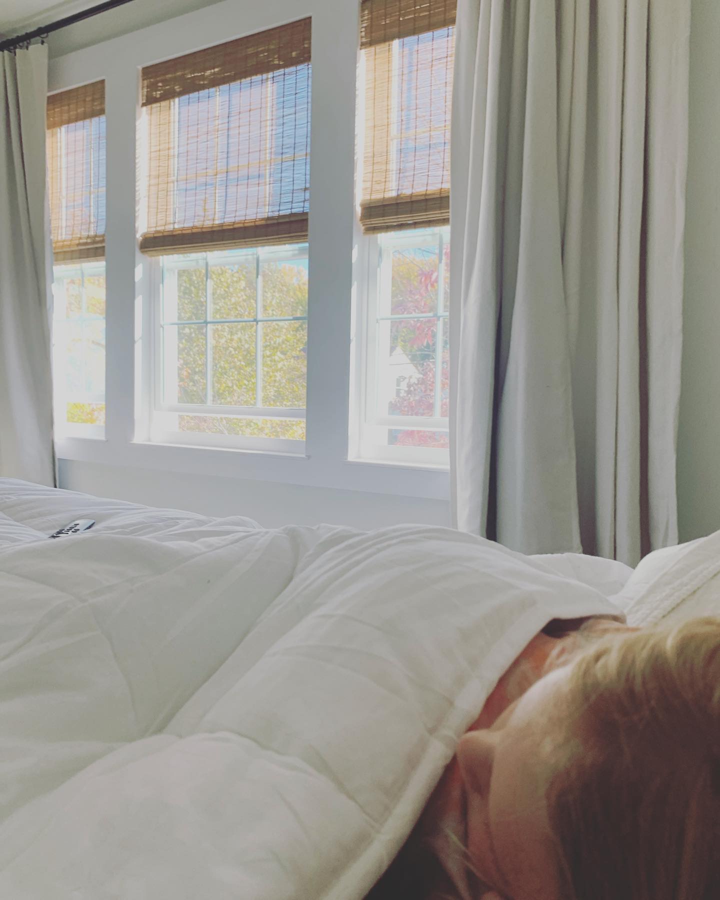 woman sleeping in bedroom with cordless woven wood shades