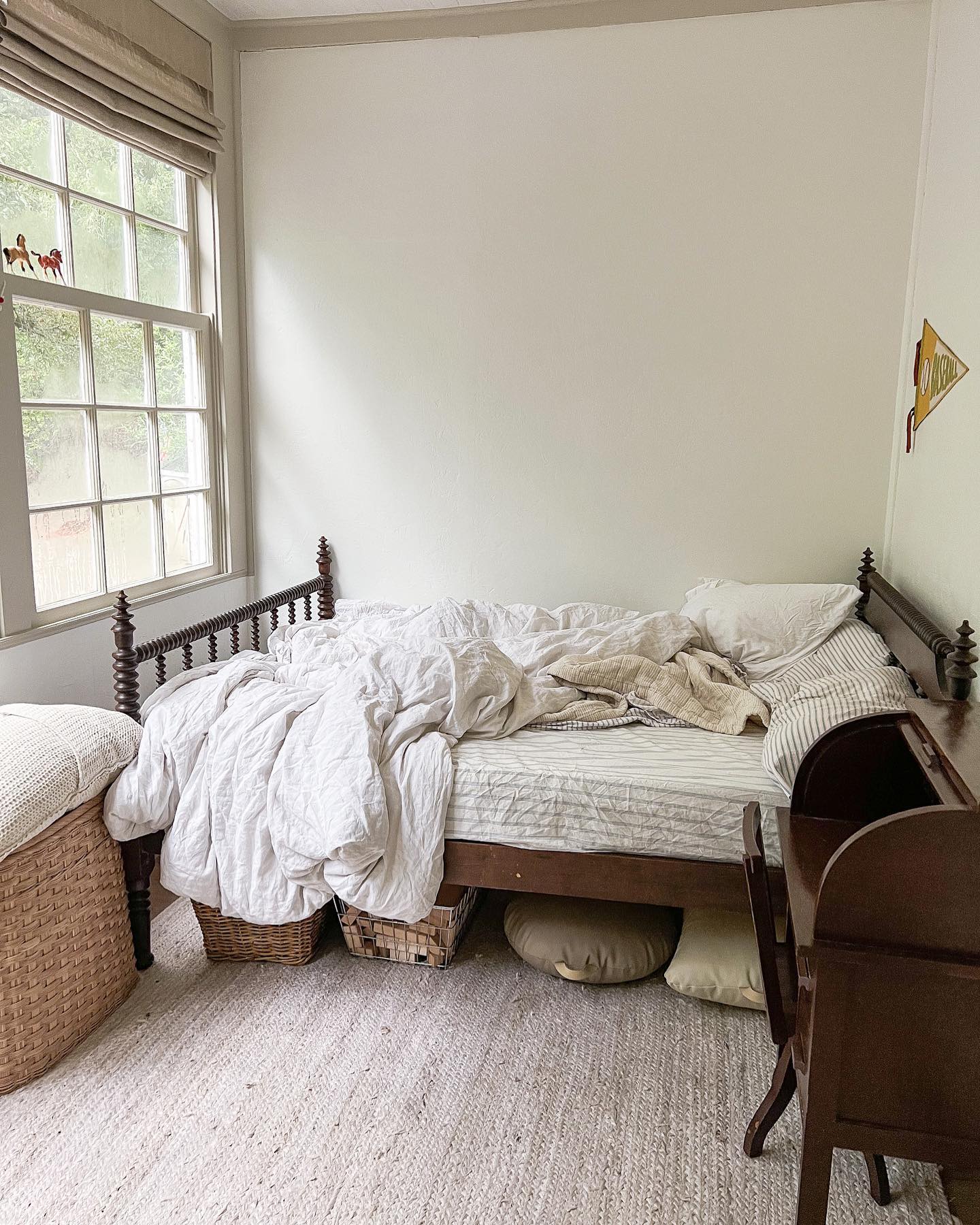 messy bedroom with roman shade window treatments
