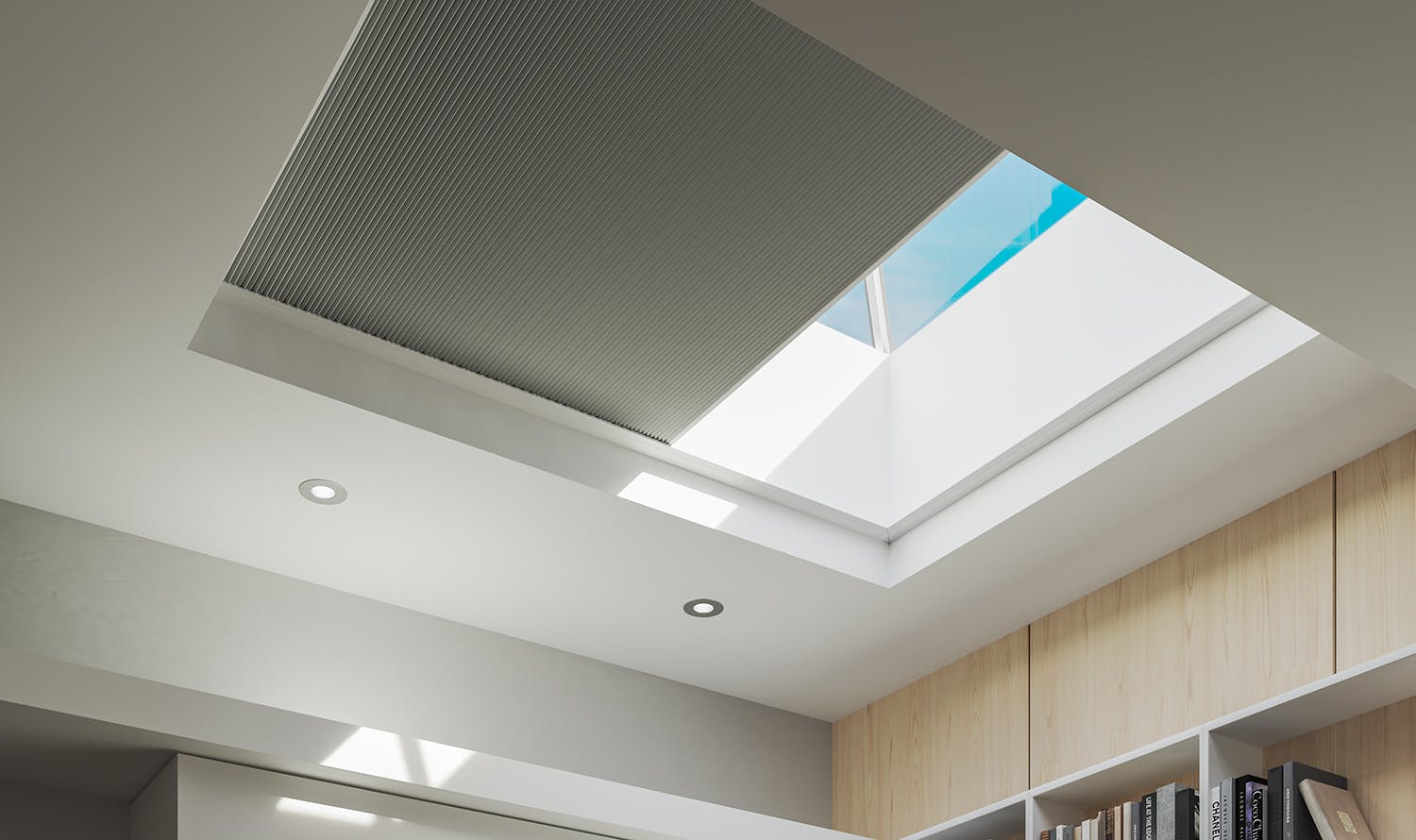 modern, sunny skylight window with a grey blackout cellular shade half way closed.
