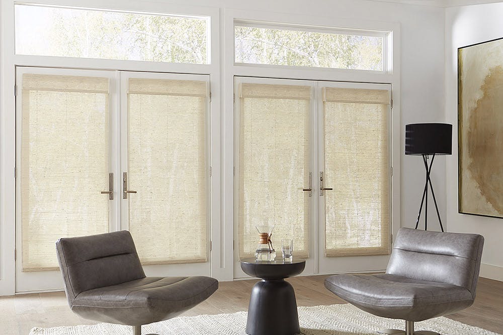 modern living room with two sets of french doors and woven wood shades.