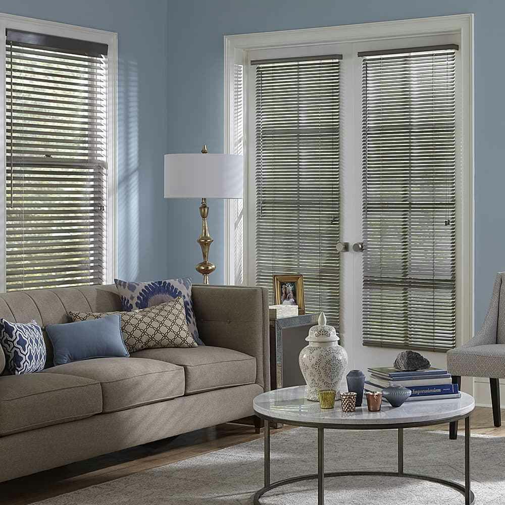 contemporary blue living room with grey wood blinds of a tall set of french doors.